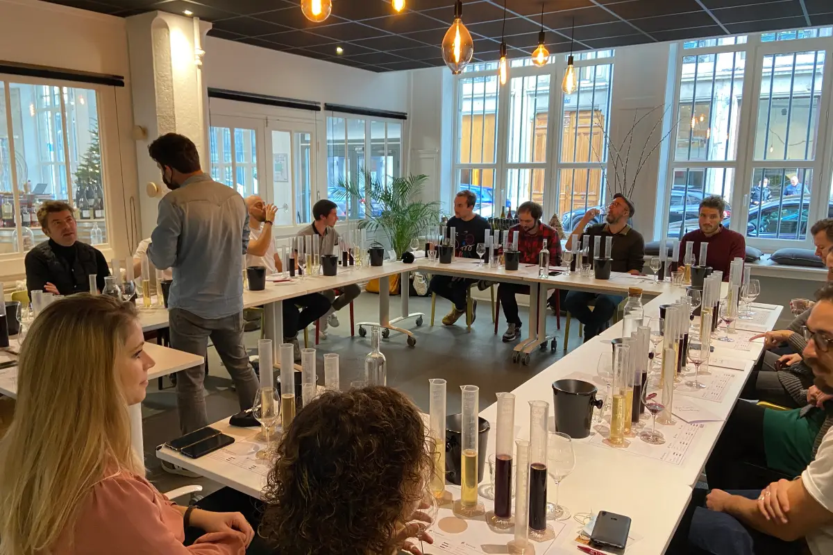 Personnes assistant à un atelier d'assemblage de vin dans un chai urbain à Lyon avec nemetia.